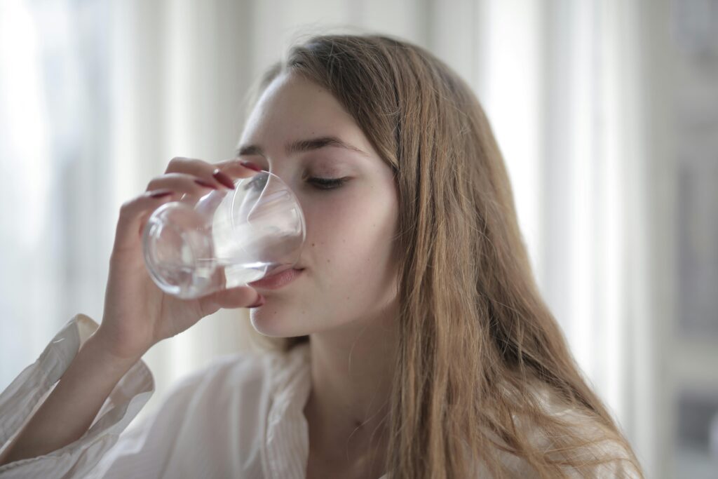 pexels-photo-3794165-3794165 A woman enjoying a refreshing glass of water indoors during the day.