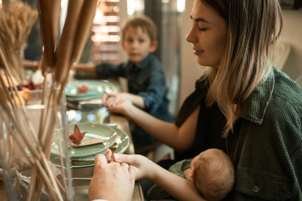 pexels-photo-5847692-5847692 A family gathered indoors sharing a meal and holding hands during Thanksgiving.