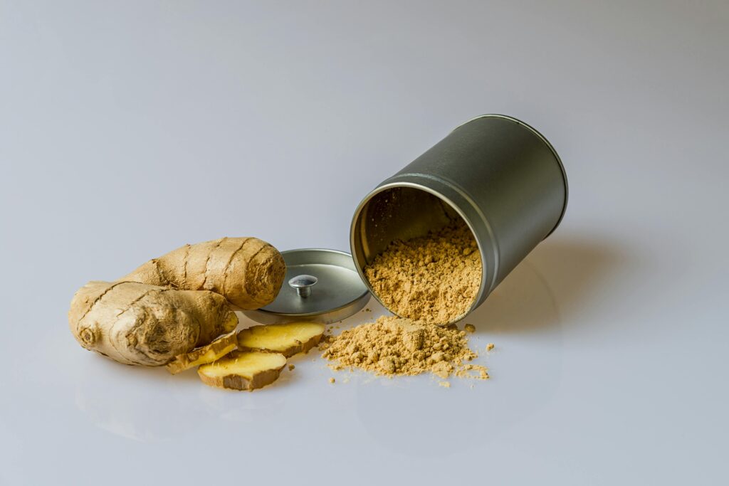 ginger-plant-asia-rhizome-161556-161556 Close-up of fresh ginger root with sliced pieces and ginger powder spilled from a metal container.