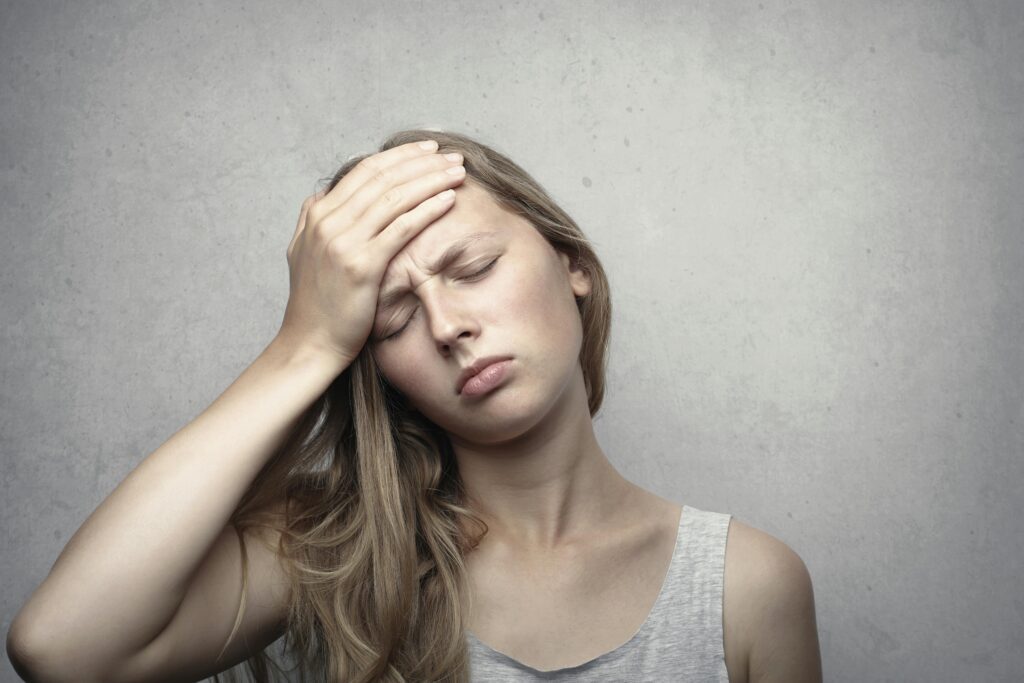 A woman in distress holding her head, expressing emotion and fatigue.