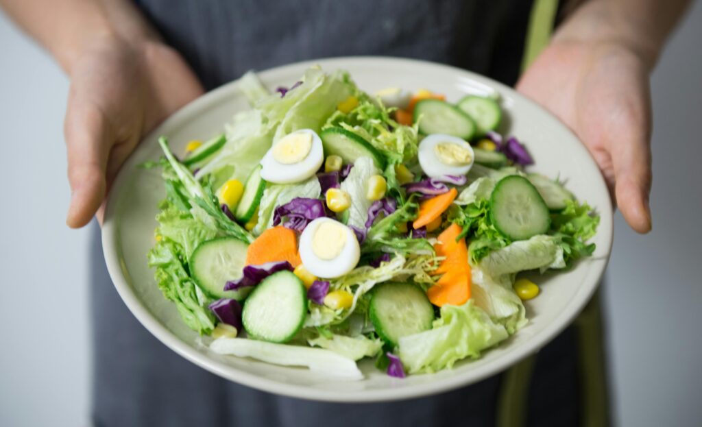 pexels-photo-406152-406152 Freshly prepared salad with cucumber, lettuce, carrots, and egg slices presented on a plate.